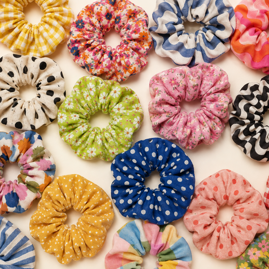 Lots of different scrunchies sitting on a table 