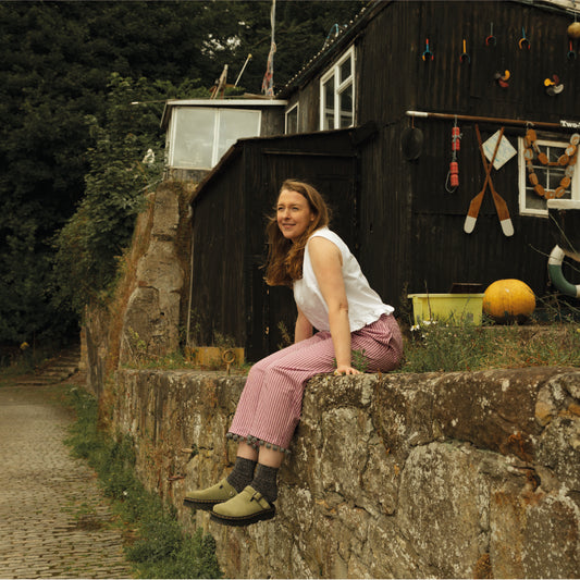 Pink stripe trousers with grey pom poms